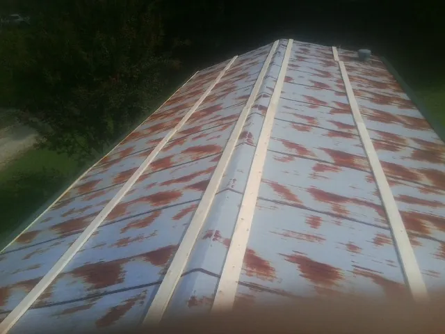 Rusted metal roof panels with new wood purlins before replacement — Storm Damage Roof Repair in Mount Pleasant Mills by Roofing Brothers