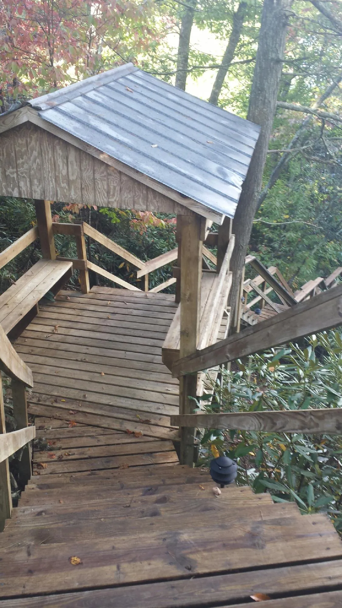 Metal roofed shelter over wooden steps on a wooded walkway — Skylight Repair & Installation work by our crew in Mount Pleasant Mills