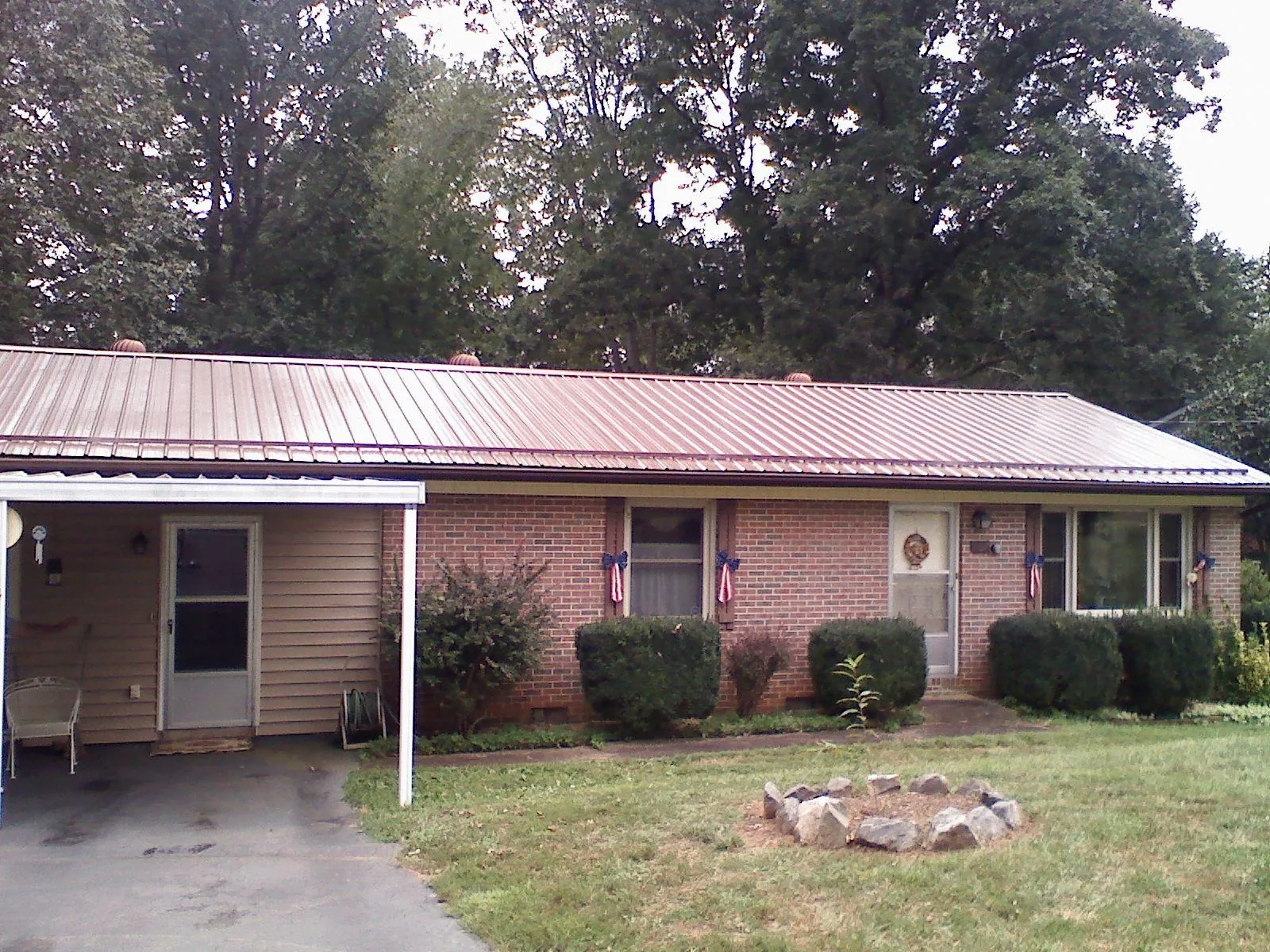 Bronze metal roof and carport on a brick ranch home — Roof Repair work by our crew in Mount Pleasant Mills